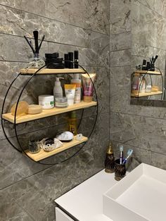 a bathroom with two shelves that have various items on them