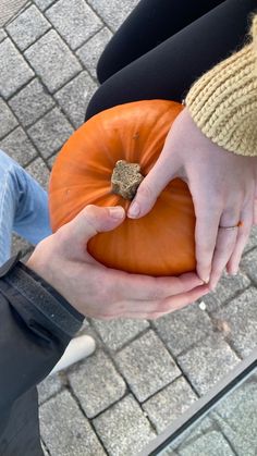 a person holding a pumpkin in their hands