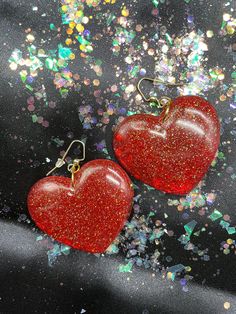 "Love Is In The Air! Big Red Heart Earrings!! Made from resin, red dye, fine white glitter, fine gold glitter and fine red glitter with gold split rings and gold fish hook findings. All connections are soldered for durability.  Earrings measure 2 1/2\" inch in drop length by about a 2\" inch in width." Red Heart Charm Earrings For Party, Red Glitter Party Earrings, Red Glitter Earrings For Party, Red Glitter Jewelry For Party, Glitter Red Earrings For Gifts, Red Glitter Earrings For Gift, Red Handmade Heart Earrings For Party, Heart-shaped Resin Earrings For Party, Heart Shaped Resin Jewelry For Party