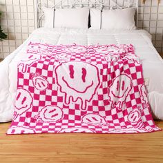 a bed with a pink and white checkered blanket on it