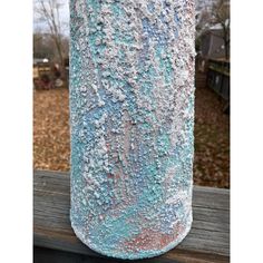 a blue and white vase sitting on top of a wooden table next to a tree