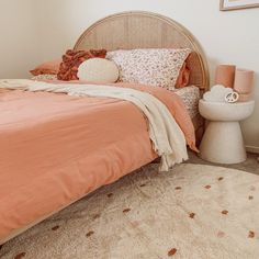 a bed with orange sheets and pillows on top of it next to a white toilet