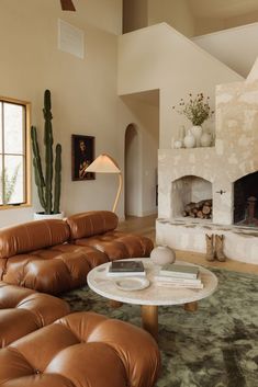 a living room filled with furniture and a fire place in the middle of the room