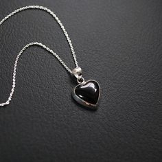 Elevate your jewelry collection with the timeless elegance of our 15mm Onyx Heart Pendant. Expertly crafted from premium 925 sterling silver, this exquisite pendant features a stunning onyx gemstone, intricately cut into a beautiful heart shape. The perfect blend of sophistication and charm, this pendant is a wonderful symbol of love and style. * Material: High-quality 925 sterling silver, renowned for its durability and lustrous finish. * Gemstone: Genuine Black onyx, providing a striking and e Black Heart-shaped Jewelry For Anniversary, Black Heart Pendant Jewelry For Formal Occasions, Black Heart-shaped Gemstone Jewelry, Black Double Heart Jewelry For Anniversary, Black Round Jewelry For Valentine's Day, Black Heart Charm Pendant Jewelry, Black Sterling Silver Double Heart Jewelry, Black Pendant Jewelry With Heart Charm, Black Sterling Silver Heart Necklace For Anniversary