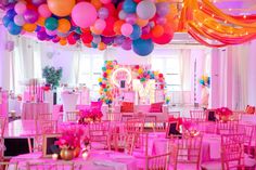 a room filled with tables and chairs covered in balloons