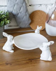 a white plate sitting on top of a wooden table next to a potted plant