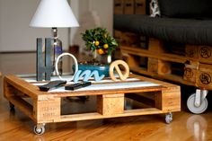 a coffee table made out of pallets with scissors and other items on it in a living room