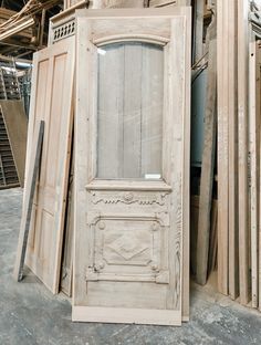 an old white door sitting next to other wooden doors