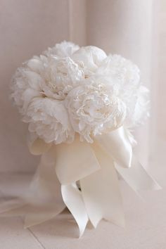 a bridal bouquet with white flowers and ribbons