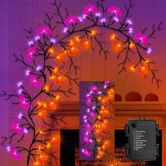 a purple and orange display with lights in the shape of a tree, next to a fire place