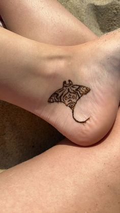 a woman's foot with a small tattoo on the side of her left leg