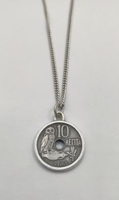 This beautiful vintage 10 Lepta coin from Greece Commonly used in the year : 1912 Turned into a one of a kind pendant In Greek mythology, a little owl (Athene noctua)  Traditionally represents or accompanies Goddess Athena. Because of such association, the bird  often referred to as the "owl of Athena". has been used as a symbol of knowledge, wisdom and perspicacity. One side shows an owl on amphora left of centre hole  Lettering: 10 ΛΕΠΤΑ CH.Pillet Translation: 10 Lepta CH.Pillet  Reverse: Crow Vintage Charm Pendant Coin Necklace, Vintage Pendant Coin Necklace With Charm, Vintage Medallion Coin Necklace, Coin Shaped Charm Necklace Gift, Coin Shaped Charm Necklace For Gift, Vintage Coin Pendant Jewelry, Antique Coin Necklace For Commemoration, Antique Round Coin Necklace Nickel Free, Antique Nickel-free Round Coin Necklace