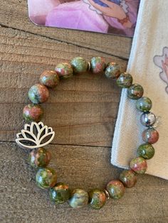 "Beautiful handmade Unakite & silver lotus flower energy beaded bracelet Made with: 8mm Unakite jasper beads, a silver lotus flower charm with a silver finish. 7 inches (average)(Stretchy). *Comes with engraved \"energy beads\" tag! **Unakite jasper beads are known as natures most healing crystals of the heart and mind. It is said to resonate with the frequencies of love and kindness and is also known for balancing the emotional body! NOTE: If need different size please let me know ill be more t Unakite Bracelet, Silver Gemstone Beaded Bracelets For Meditation, Silver Beaded Bracelets With Gemstone Beads For Meditation, Holistic Silver Bracelet With Round Beads, Holistic Silver Bracelets With Round Beads, Silver Beaded Bracelets With 8mm Beads For Meditation, Acrylic Nails Almond Shape, Emotional Body, Natural Stone Jewelry