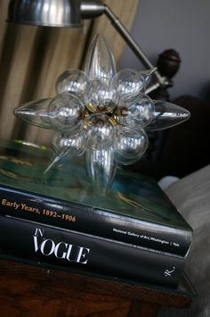 a clear glass flower on top of a book