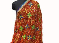 Pattern - embroidered/ phulkari embroidery.It is an embroidery technique from regions of Punjab in India. Phulkari means flowers, specially worn during marriages and functions. Ideal for - women. Occasion - formal or casual. Fabric - soft chiffon. It is embroidered with different silk threads.There is a light golden and multicolored frilly border on all the four sides. Color - Multicolored. Orange back ground has embroidery in different silk threads, with geometrical flowers all over. Can be wra Orange Pallu Dupatta For Navratri, Orange Dupatta For Navratri With Traditional Drape, Orange Dupatta With Pallu For Navratri, Orange Bollywood Dupatta For Festivals, Orange Dupatta For Navratri Festive, Festive Orange Dupatta For Navratri, Bohemian Red Dupatta With Dori Work, Traditional Orange Embroidered Fabric For Diwali, Eid Orange Dupatta With Chikankari Embroidery