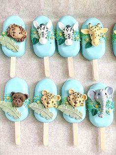 a table topped with blue cake pops covered in animals