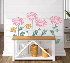 a bench with flowers painted on the wall behind it