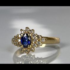 a gold ring with a blue stone surrounded by diamonds