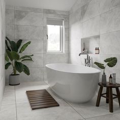 a large white bath tub sitting in a bathroom next to a plant on the floor