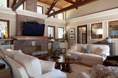 a living room filled with furniture and a flat screen tv mounted on the wall above a fireplace