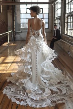 a woman in a white wedding dress standing on a wooden floor with an open window