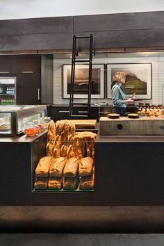 a woman standing in front of a counter filled with food