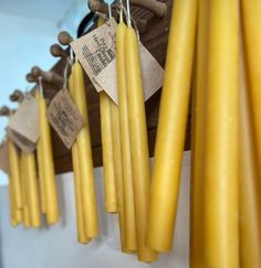 yellow candles hanging from hooks with tags on them