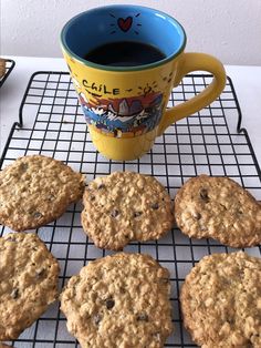 cookies cooling on a wire rack next to a cup of coffee