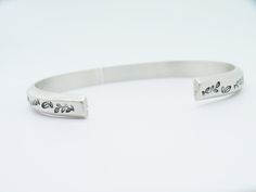 "This floral cuff is a sturdy sterling silver piece, ideal for men and women. Entirely handmade and hand textured with leaves stamps, these open bangles can be made with a 4mm silver wire (€85) or with a 6mm wire(€115). You'll be prompt to select your preferences. BANGLE SIZES To determine your size, you'll need to measure your wrist circumference. XS - Circumference (including opening) 6\" S - circumference (including opening) 6,5\" M - circumference (including opening) 7\" L - circumference (i Stamped Sterling Silver Cuff Bracelet, Sterling Silver Stamped Cuff Bangle, Engraved Adjustable Sterling Silver Cuff Bracelet, Engraved Sterling Silver Adjustable Cuff Bracelet, Adjustable Etched Cuff Bracelet For Anniversary, Etched Sterling Silver Cuff Bracelet Gift, Adjustable Sterling Silver Stamped Cuff Bracelet, Beautiful Arms, Floral Cuff