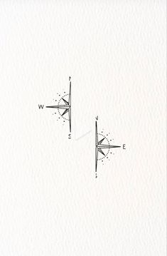 two compasss are drawn on paper with one pointing to the opposite direction and the other pointing