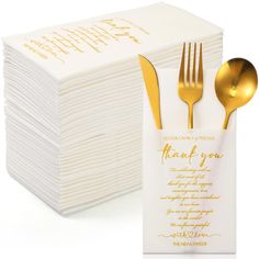 a stack of white napkins with gold forks and spoons next to each other