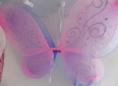 a pink and purple butterfly on a white wall