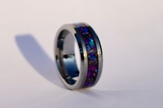 a ring with purple and blue opal inlays on the inside of it