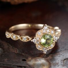 a yellow and white diamond ring on top of a wooden table with other jewelry items