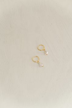 Description Gold clasp hoops with a hanging pearl. Material Sterling Silver 925 Care Remove before showering, sleeping, or any activities that may result in contact with moisture or friction. Sterling silver is soft and flexible, so if your earring post needs a little adjusting, it is totally normal. Clean after every use with the cloth provided to keep them looking new Lastly, store your pieces when not wearing them to avoid any damage. Dainty Adjustable Hoop Earrings With Pearl Drop, Adjustable Hoop Pearl Drop Earrings, Adjustable Hoop Earrings With Pearl Charm As Gift, Silver Huggie Pearl Earrings For Everyday, Silver Huggie Earrings With Pearl Drop, Silver Huggie Hoop Earrings With Pearl Charm, Phone Items, Ear Stack, Earring Post