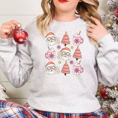 Get into the holiday spirit with our Groovy Santa Pink Christmas and Holiday Drink T-Shirt, Sweatshirt, or Hoodie. Featuring a groovy Santa and festive holiday drink design, this top is perfect for adding some fun to your wardrobe. Available in three styles - t-shirt, sweatshirt or hoodie - you can choose the fit that suits you best. Spread some cheer this season with our Groovy Santa Pink Christmas and Holiday Drink top. Key Features: - Festive Groovy Santa design - Fun holiday drink graphic - Available in t-shirt, sweatshirt or hoodie styles  Whether you're looking for a cozy sweatshirt to snuggle up in on cold winter nights or a casual t-shirt that expresses your festive spirit at any time of day, we've got you covered. The pink color adds an extra touch of whimsy to this jolly design. Cozy Christmas Tops With Relaxed Fit, Cozy Relaxed Fit Christmas Tops, Casual Christmas Sweatshirt For Festive Occasion, Cozy Christmas Sweatshirt With Relaxed Fit, Casual Christmas Festive Sweatshirt, Cozy Relaxed Fit Christmas Sweatshirt, Casual Christmas Sweater For Loungewear, Casual Holiday Hoodie With Crew Neck, Casual Crew Neck Hoodie For Holiday