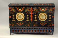 an ornately painted chest with two initials on the front and one letter at the bottom