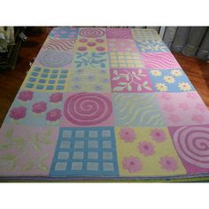 a multicolored rug with flowers and swirls on the floor in front of a radiator