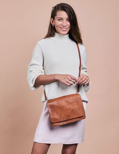 Our Audrey is a sleek and minimalist design that works well no matter the season or your outfit! The smooth leather satchel has an external front compartment and a canvas-lined interior that features a roomy compartment with a zipped side pocket for your belongings. Two open inside pockets make it easy to stow away smaller items. And we haven't got to the best bit yet - this bag comes with two straps! Feeling like switching up your look, while keeping it classy? Use the checkered strap and every Modern Brown Satchel With Detachable Strap, Modern Brown Saddle Bag Satchel, Timeless Shoulder Bag For Travel In Fall, Versatile Cognac Satchel With Leather Handles, Timeless Brown Flap Bag For Everyday Use, Timeless Everyday Satchel Flap Bag, Everyday Timeless Satchel Flap Bag, Modern Satchel Flap Bag With Leather Handles, Modern Flap Bag With Leather Handles For Travel