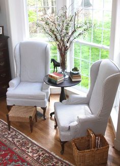 two chairs and a table in front of a window with a dog figurine on it