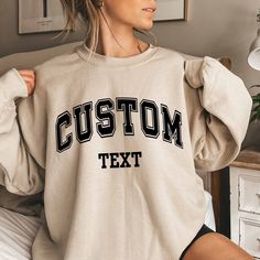 Custom Text Sweatshirt Vintage College Letters Sweatshirt Gift Retro Oversized Sweater Personalized Add Your Own Text Custom Quote Varsity Plus sizes also available: 2X, 3X, 4X, 5X -------- HOW TO ORDER -------- 1) Select your sweatshirt Size 2) Select your desired Color 3) Add personalization. 4) Click "Add to Cart" and place your order. 5) Repeat for more items. Ideal for any situation, a unisex heavy blend crewneck sweatshirt is pure comfort. These garments are made from polyester and cotton. Oversized T-shirt With Ribbed Cuffs For College, College Letter Print Drop Shoulder Tops, Oversized Crew Neck Hoodie With Lettering, Oversized Crew Sweater With Letter Print, Oversized Varsity Sweatshirt With Text Print, Custom Text Sweatshirt With Relaxed Fit For Fall, Oversized Varsity Sweatshirt With Lettering, Custom Text Relaxed Fit Long Sleeve Sweatshirt, Custom Text Long Sleeve Relaxed Fit Sweatshirt