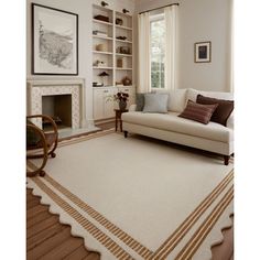 a living room filled with furniture and a white rug on top of a hard wood floor