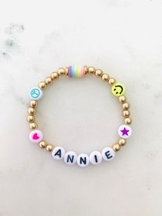 🌈 Colorful emoji beads with matte gold accents make this name bracelet one of the cutest. Can be made in adult or child sizes. Please note name/word and any color preference of the heart, star or peace sign in the personalization section. 🌈 Listing is for ONE bracelet.  🌈 Sizing length is as follows:  Women's small: 6.5 inches Women's medium: 7 inches Women's large: 7.5 inches Women's XL: 8 inches Children's 4-5 years old: 5.75 inches Children's 6-7 years old: 6 inches Children's 8-9 years old: 6.25 inches Children's 10-13 years old: 6-7 inches **Please measure wrist before ordering. Bracelets are stretchy but you do not want them to be super loose around your wrist.  🌈 All orders are FINAL SALE. These are custom bracelets made to order. PLEASE DOUBLE CHECK ALL SPELLING AND COLOR SELEC Playful Adjustable Name Bracelet For Everyday, Playful Personalized Beaded Bracelets, Everyday Playful Personalized Beaded Bracelets, Trendy Personalized Beaded Bracelets, Playful Personalized Everyday Stretch Bracelet, Trendy Personalized Beaded Bracelets For Everyday, Trendy Name Bracelet For Birthday, Customizable Playful Everyday Jewelry, Trendy Personalized Charm Bracelet For Birthday