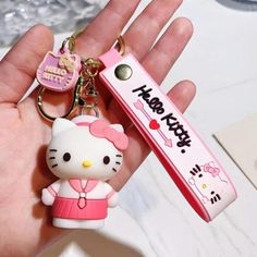 a hello kitty keychain that is in someone's hand