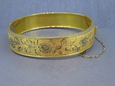 Gorgeous Victorian revival antique bangle.  Has a box clasp that works great and fixed safety chain.  Signed 1/20th 10k gold filled.  Visit Ribbons Edge for more great pieces of vintage and antique jewelry!  All items added to your cart at Ribbons Edge will automatically combine shipping. To stay up to date with my newest offerings, follow me on IG @ RibbonsEdge Antique Gold Bracelets With Box Clasp, Antique Gold Cuff Bracelet With 17 Jewels, Antique Yellow Gold Bracelet For Ceremonial Occasions, Victorian Gold Hinged Bangle, Antique Gold Hinged Cuff Bracelet, Antique Gold Cuff Bracelet Collectible, Gold Victorian Hinged Bangle, Antique Yellow Gold Cuff Bracelet For Ceremonial Occasions, Vintage Yellow Gold Cuff Bracelet For Ceremonial Occasions