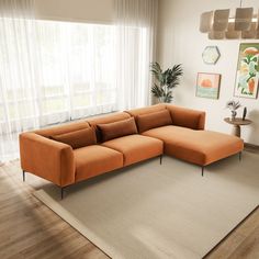 an orange sectional sofa sitting on top of a rug in front of a large window