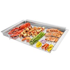 a large tray with different types of seafood on it and vegetables in the bottom right hand corner