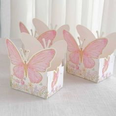 three pink butterfly shaped boxes sitting on top of a table