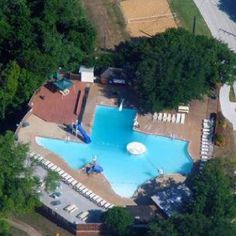 an aerial view of a swimming pool surrounded by trees