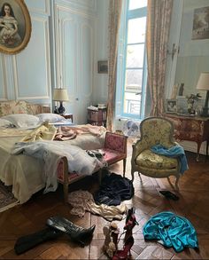 a bed room with a neatly made bed and lots of clothes on the floor